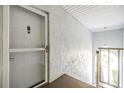 Condo entryway with a security door and textured walls, providing security and privacy at 387 S Mcmullen Booth Rd # 16, Clearwater, FL 33759