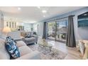 Open-concept living room with sliding doors to a balcony and modern furnishings at 387 S Mcmullen Booth Rd # 16, Clearwater, FL 33759