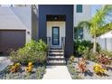 Inviting front entrance with modern black door, well maintained landscaping, and lovely pavers at 4604 W Euclid Ave, Tampa, FL 33629
