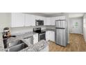 Well-lit kitchen featuring stainless steel appliances, granite countertops, and white cabinets at 501 74Th N Ave, St Petersburg, FL 33702