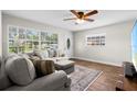 Bright living room with wood floors, a plush sectional sofa, and a large window providing ample natural light at 501 74Th N Ave, St Petersburg, FL 33702