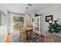 Elegant dining area with modern chandelier, hardwood floors, and light-filled balcony access at 507 S Willow Ave, Tampa, FL 33606