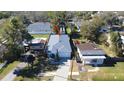 Aerial view of a well-maintained home with a gray roof and brick-paved driveway surrounded by lush greenery at 5528 40Th N St, St Petersburg, FL 33714