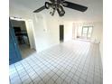 Living room featuring tile floors, a ceiling fan, and a view into the kitchen at 6342 Newtown Cir # A4, Tampa, FL 33615