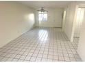 Open living room features tile floors and neutral walls, with a window and entry door at 6342 Newtown Cir # A4, Tampa, FL 33615