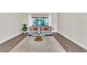 This cozy living room features a comfortable sofa and a large window offering scenic views at 910 Kingscote Ct, Safety Harbor, FL 34695