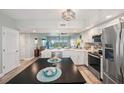 Modern kitchen with stainless steel appliances and center island open to living area at 960 Starkey Rd # 10505, Largo, FL 33771