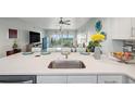Bright kitchen with white countertops, stainless sink, and a view into the living area at 960 Starkey Rd # 10505, Largo, FL 33771