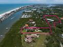 An aerial view showing property boundaries, a beautiful waterfront home, guest house, and the nearby beach at 10930 Spring St, Largo, FL 33774
