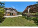 A rustic barn with large doors, a well-maintained field, and covered area for horses or storage at 10930 Spring St, Largo, FL 33774