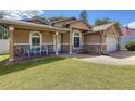 Inviting front porch with stone accents and quaint seating offering a welcoming entry to the residence at 11362 Heritage Way, Largo, FL 33778