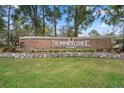 Community sign for Summertree shows brick wall with stone base and decorative holiday wreath at 11439 Golf Round Dr, New Port Richey, FL 34654
