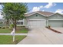 Home exterior featuring a well-kept lawn, mailbox, and a two-car garage with a driveway at 11439 Golf Round Dr, New Port Richey, FL 34654