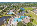 Aerial view of a community with multiple pools, sports courts, and ponds surrounded by lush landscaping at 11830 Autumn Creek Dr, Riverview, FL 33569