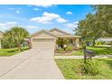 Beautiful single-story home featuring a well-kept lawn, front garden, and an attached two-car garage at 11830 Autumn Creek Dr, Riverview, FL 33569