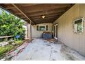 Covered back porch area, featuring a concrete floor and access to the home at 1213 Cuttingin Pl, Tampa, FL 33612