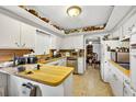 Kitchen with wood countertops, white cabinetry, and vintage decor at 1213 Cuttingin Pl, Tampa, FL 33612