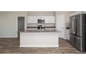 Modern kitchen featuring white cabinets, stainless steel appliances, and a center island at 14817 Summer Branch Dr, Lithia, FL 33547