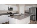 Well-lit kitchen features stainless appliances, ample counter space, and streamlined design at 14817 Summer Branch Dr, Lithia, FL 33547
