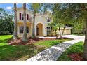 Inviting two-story home with manicured landscaping, a paver driveway, and a charming arched front entryway at 16102 Colchester Palms Dr, Tampa, FL 33647