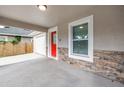 Covered front porch with a bright red door, stone accents and lighting at 1717 Preston S St, St Petersburg, FL 33712