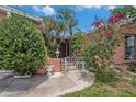 Inviting front entrance with a decorative gate, lush plants, and a potted plant at 1741 Font Ln, Holiday, FL 34691