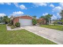 Single-Gathering home featuring a driveway, a garage, and a well-maintained lawn at 1741 Font Ln, Holiday, FL 34691
