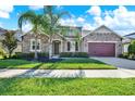 Beautiful single-story home featuring stone accents, a manicured lawn, and a two-car garage at 2120 Gwynhurst Blvd, Wesley Chapel, FL 33543