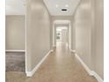 Hallway with tile floors, neutral paint, and archways leading to other rooms at 2120 Gwynhurst Blvd, Wesley Chapel, FL 33543