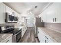 Modern kitchen with stainless steel appliances, granite countertops, and sleek, white cabinets at 2121 Odessa Gardens Ln, Odessa, FL 33556