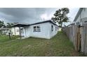 Side yard showing the side of a single-story home with a wooden fence at 2410 38Th N Ave, St Petersburg, FL 33713