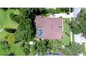 Aerial view of a private residence featuring a screened-in pool, mature trees, and a well-maintained lawn at 2504 Oak Landing Dr, Brandon, FL 33511