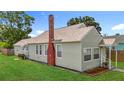 Charming home featuring a well-maintained lawn, red brick chimney, and light green siding at 3327 25Th N St, St Petersburg, FL 33713