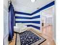 Stylish living room featuring a white leather chair, blue striped walls, and hardwood floors at 3327 25Th N St, St Petersburg, FL 33713