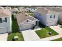 Aerial view showcasing this well-kept gray home, neighboring properties, and lush green lawns in a tidy neighborhood at 34033 Jasper Stone Dr, Wesley Chapel, FL 33543