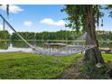 Hammock facing a lake with a dock and seating at 3620 Little Rd, Lutz, FL 33548