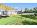 A spacious backyard with green grass, a sunshade, and a white fence creating a private outdoor space at 4015 Overlook Ne Dr, St Petersburg, FL 33703