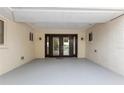 A covered entrance with beautiful double doors, exterior lights, and views of the front yard at 4157 Marine Pkwy, New Port Richey, FL 34652