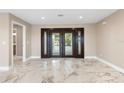 Bright foyer with marble tile flooring and a large front door with sidelights, and a view into the bathroom at 4157 Marine Pkwy, New Port Richey, FL 34652