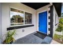 Inviting entryway featuring a bright blue front door, modern tile flooring, and lush greenery at 4441 16Th N St, St Petersburg, FL 33703
