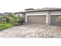 Beautiful single-story home featuring a well-maintained lawn, manicured landscaping, and a two-car garage with a paver driveway at 4957 Seafoam Trl, Bradenton, FL 34211