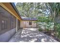 Backyard patio featuring a screened-in porch and a spacious outdoor area with mature trees at 512 Pinewalk Dr, Brandon, FL 33510