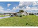 Attractive home featuring a carport, mature landscaping, and a well-maintained lawn, adding to its inviting curb appeal at 5706 Benton St, Zephyrhills, FL 33542