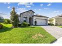 Charming single-story home featuring a stone facade, manicured lawn, and a paved driveway leading to a two-car garage at 6211 Sea Air Dr, Apollo Beach, FL 33572