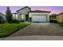 Charming single-story home featuring a stone facade, manicured lawn, and a paved driveway leading to a two-car garage at 6211 Sea Air Dr, Apollo Beach, FL 33572