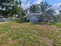 View of home featuring lawn area and attractive tropical trees at 7001 60Th N St, Pinellas Park, FL 33781