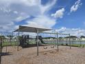 Community playground featuring a covered play structure and swings, perfect for Gathering fun at 7575 Sail Clover Ln, Zephyrhills, FL 33540