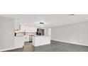 Modern kitchen with sleek gray floors, white cabinets, stainless steel appliances, and stylish island lighting at 7835 Wallaba Ln, New Port Richey, FL 34653