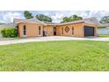 Charming single-story home featuring a large driveway and black garage door, with a well-maintained lawn at 8927 95Th N St, Seminole, FL 33777