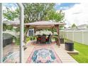 Inviting backyard with patio, gazebo with table and chairs, plus a well-maintained lawn perfect for relaxation and entertaining at 9016 Water Chestnut Dr, Temple Terrace, FL 33637